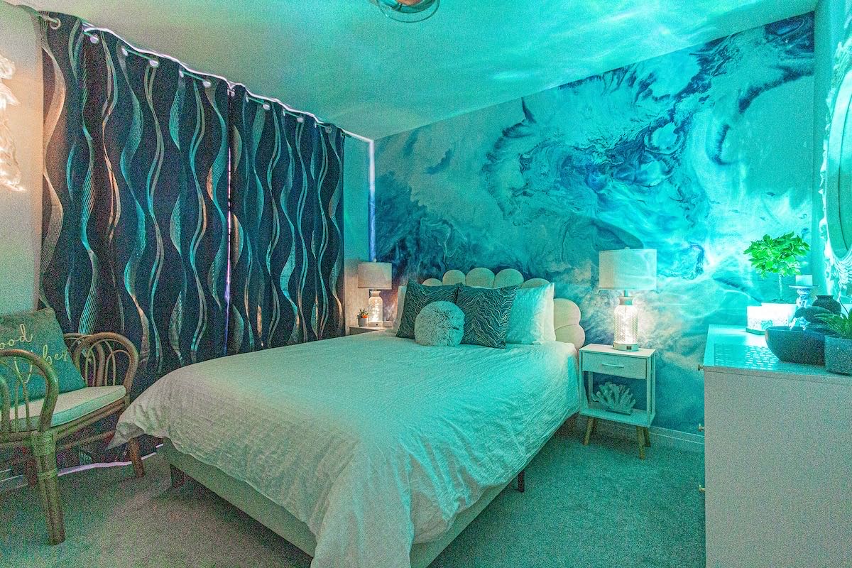 The Water Room: a queen bed beneath a blue water mural