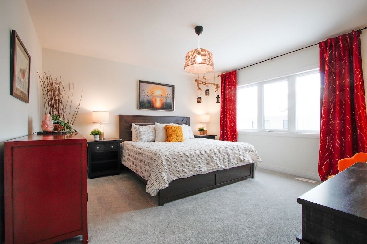 The Fire Room: a king bed with red curtains and warm wood furniture